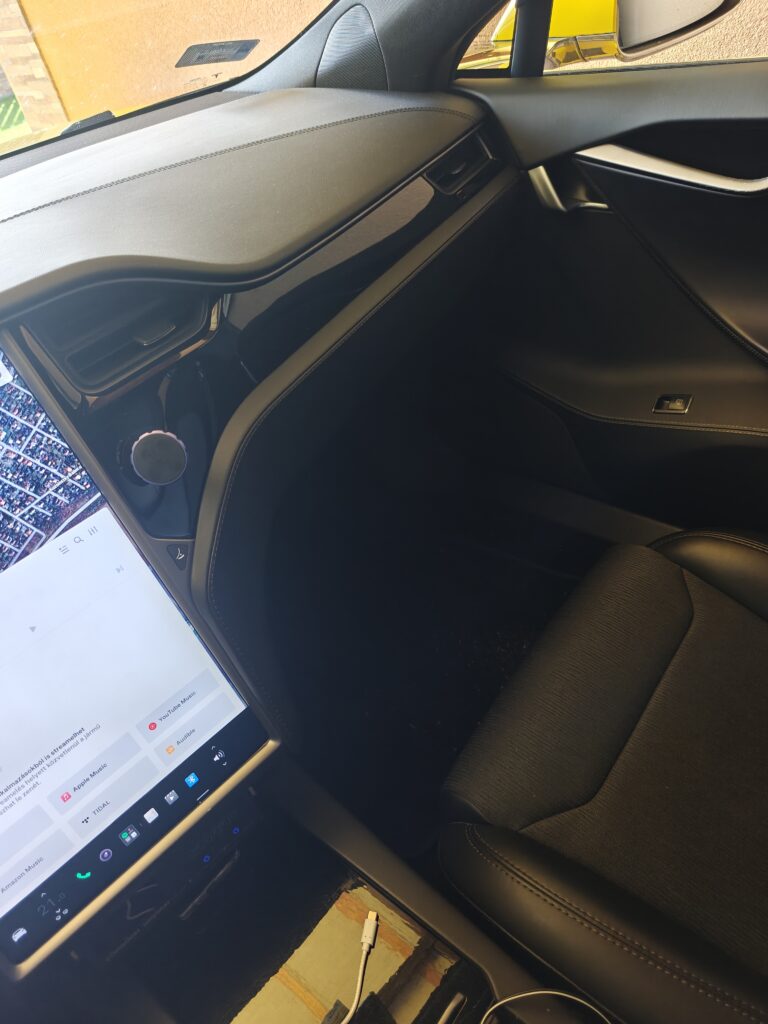 Siófok eTaxi – A prémium sárga Tesla Model S taxi gépjármű tágas utastere az első utasülés felől, bemutatva a hatalmas lábteret és az elérhető USB töltő csatlakozót.