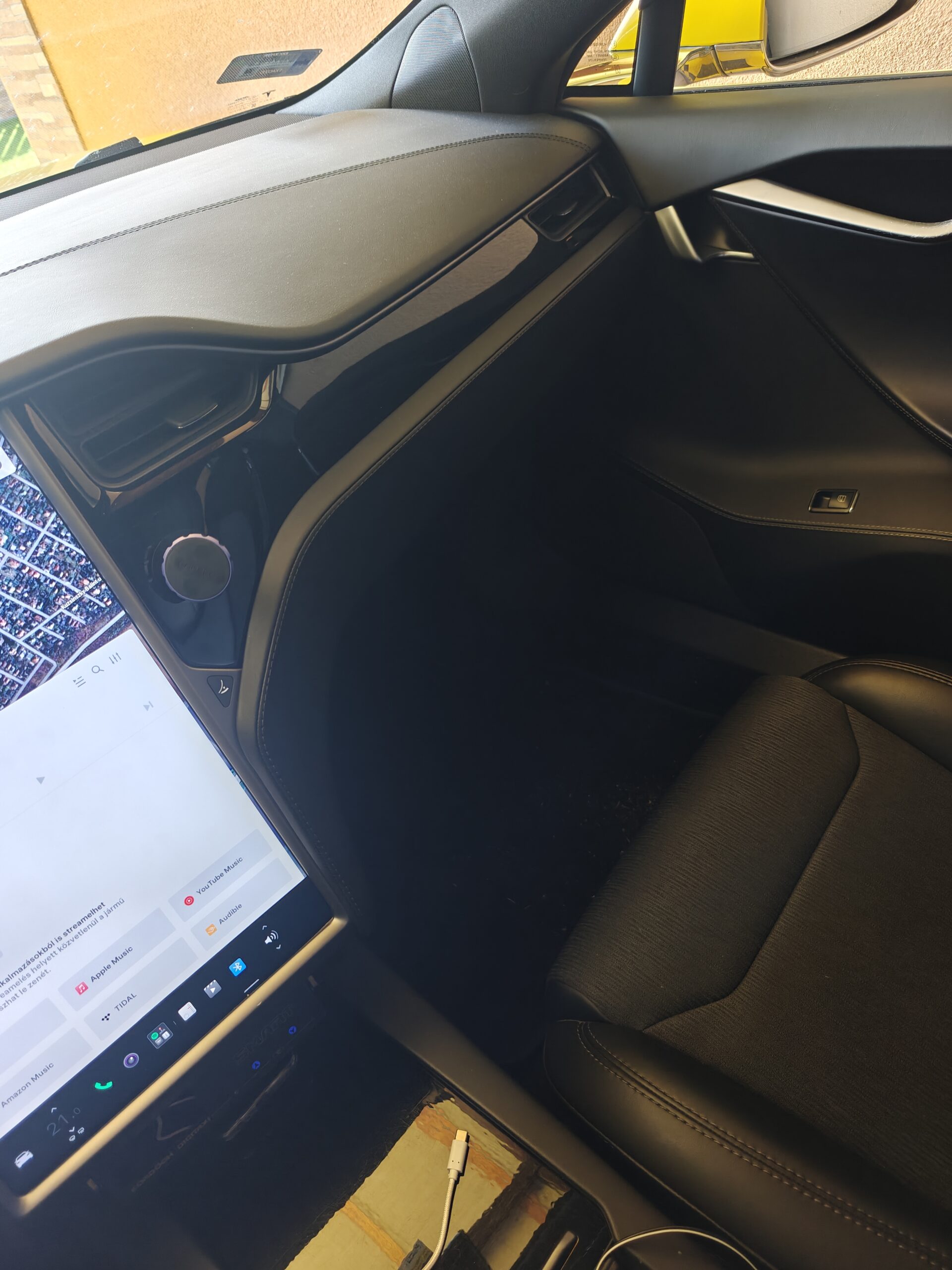 Siófok eTaxi – A prémium sárga Tesla Model S taxi gépjármű tágas utastere az első utasülés felől, bemutatva a hatalmas lábteret és az elérhető USB töltő csatlakozót.
